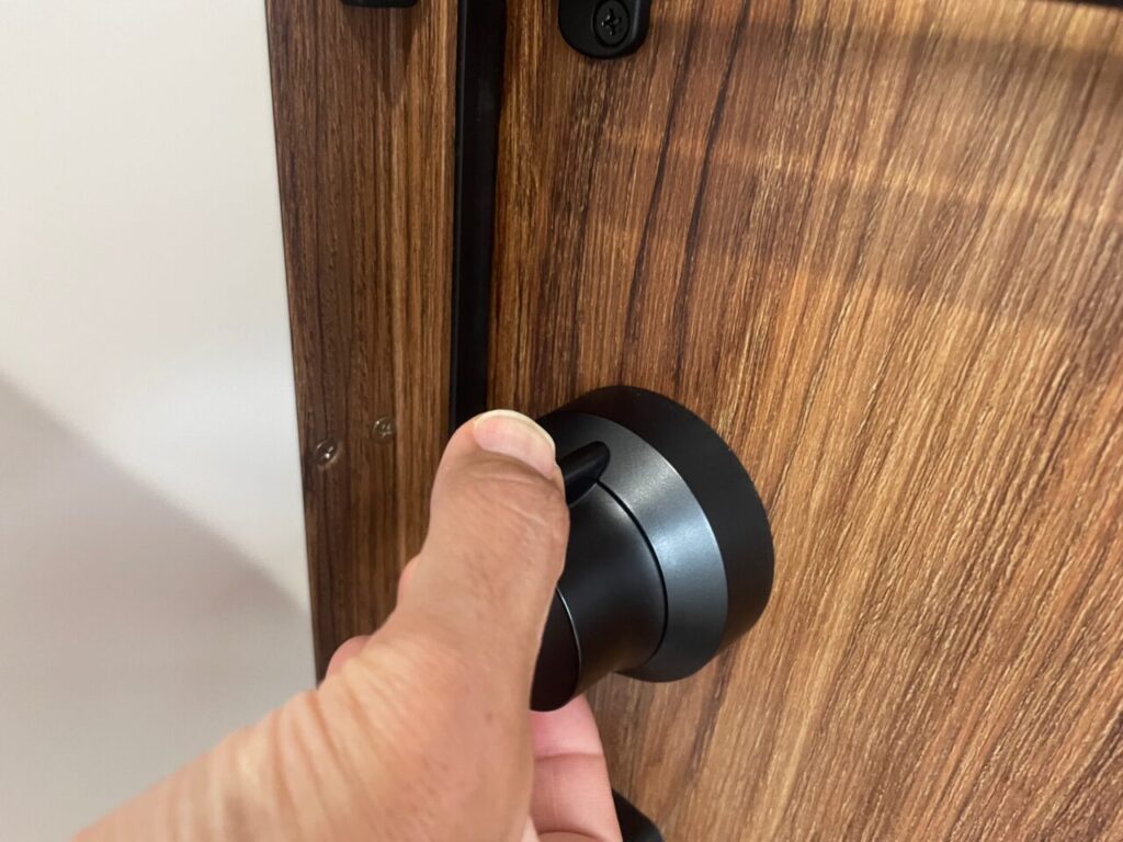 玄関ドアの鍵の下のボタンを押します。