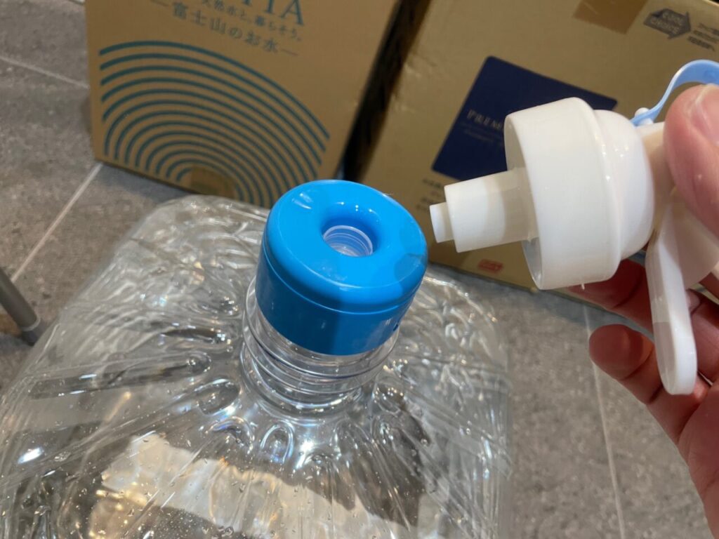 プレミアムウォーターの天然水ボトルにポータブルボトルスタンド蛇口コックを接続します