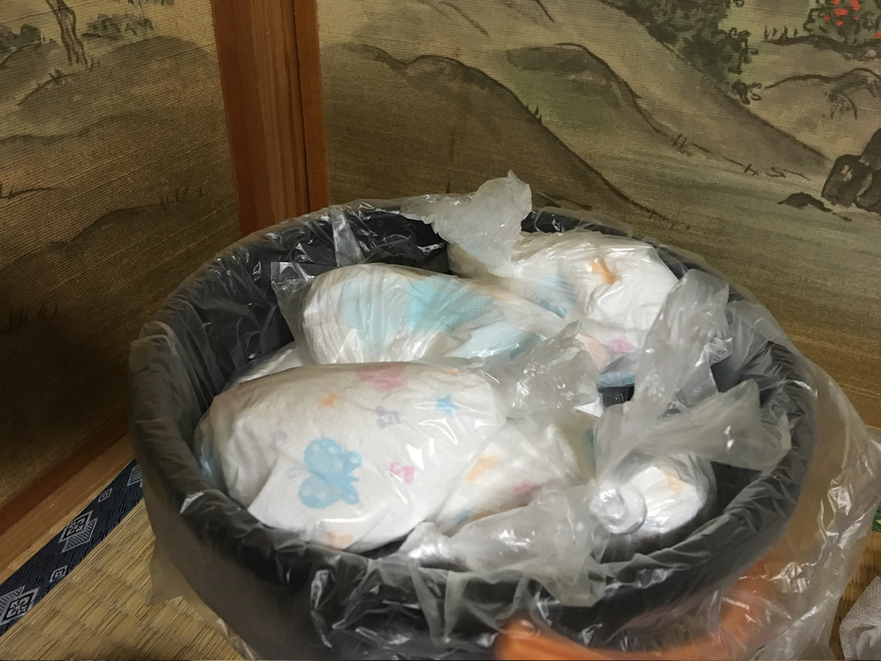 オムツを袋に入れてゴミ箱へ